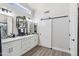 Modern bathroom with double vanity, large mirror, and barn door at 15045 W Mulberry Dr, Goodyear, AZ 85395