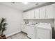 Bright laundry room with white cabinets, washer, and dryer at 15045 W Mulberry Dr, Goodyear, AZ 85395