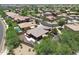 An aerial view showcasing a house with a pool, surrounded by other homes and desert landscaping at 15338 W Montecito Ave, Goodyear, AZ 85395