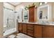 Elegant bathroom with double sinks, large shower, and wood cabinets at 15338 W Montecito Ave, Goodyear, AZ 85395