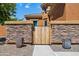 Backyard with wood gate and stone wall at 15338 W Montecito Ave, Goodyear, AZ 85395