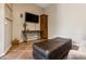 Cozy sitting room with a TV, comfortable ottoman, and wood cabinet at 15338 W Montecito Ave, Goodyear, AZ 85395