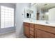 Bathroom with double sinks, wood cabinets, and large mirror at 15548 N 156Th Ln, Surprise, AZ 85374