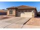 Front view of a one-story house with a tan exterior at 15548 N 156Th Ln, Surprise, AZ 85374