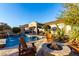 A desert backyard offers a refreshing pool, inviting fire pit, and comfortable seating for outdoor enjoyment at 17833 W Verdin Rd, Goodyear, AZ 85338