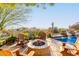 Desert backyard with a water feature that flows into the pool and seating near the fire pit and mountain views at 17833 W Verdin Rd, Goodyear, AZ 85338