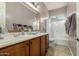 Well-lit bathroom boasts dual sinks, framed mirror, and a shower/tub combo with a large window at 17833 W Verdin Rd, Goodyear, AZ 85338