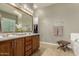 Bathroom featuring double sinks, a large mirror with vanity lighting, and a walk-in closet at 17833 W Verdin Rd, Goodyear, AZ 85338