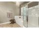 Bright bathroom with a shower, a soaking tub with tile surround and a decorative fish art piece at 17833 W Verdin Rd, Goodyear, AZ 85338