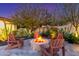 Beautiful desert landscape features a stone fire pit, with seating and lush foliage surrounding the patio space at 17833 W Verdin Rd, Goodyear, AZ 85338