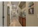 Well-lit hallway with artwork, cabinet storage, and tile flooring, creating an inviting space at 17833 W Verdin Rd, Goodyear, AZ 85338