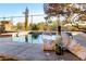 Relaxing poolside setting with wine, glasses, and towel, overlooking serene desert landscape at 17833 W Verdin Rd, Goodyear, AZ 85338