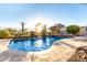 Sparkling pool and spa with rock waterfall feature, desert landscaping, and sunlit ambiance at 17833 W Verdin Rd, Goodyear, AZ 85338