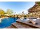 Outdoor pool area with a spa, rock waterfall feature, and views of the surrounding desert landscape at 17833 W Verdin Rd, Goodyear, AZ 85338