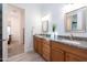 Bathroom with double sinks, granite countertops, and wood cabinets at 18206 W Solano Ct, Litchfield Park, AZ 85340