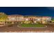 Inviting single-story home with a well-manicured lawn and decorative rock landscaping illuminated at night at 18206 W Solano Ct, Litchfield Park, AZ 85340