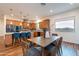 Open kitchen and dining area featuring wood cabinets, stainless appliances, and a breakfast bar at 18206 W Solano Ct, Litchfield Park, AZ 85340