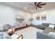 Bright living room with a gray sofa, modern furniture, and a ceiling fan at 18206 W Solano Ct, Litchfield Park, AZ 85340