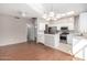 Kitchen features white cabinets, stainless steel appliances, and hardwood floors at 18212 N 136Th Ave, Sun City West, AZ 85375