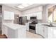 Modern kitchen with white cabinets, stainless steel appliances, and an island at 18212 N 136Th Ave, Sun City West, AZ 85375