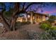 House exterior at dusk, featuring a covered entryway and mature tree at 19275 N 88Th Way, Scottsdale, AZ 85255