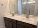 Bathroom featuring double sinks, framed mirror, and glass-enclosed shower at 20634 N 226Th Dr, Surprise, AZ 85387