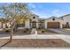 One-story home with tan exterior, brown garage door, and landscaped yard at 22847 E Sonoqui Blvd, Queen Creek, AZ 85142