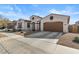 Tan house with a brown garage door and small front yard at 22847 E Sonoqui Blvd, Queen Creek, AZ 85142