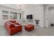 Spacious living room featuring a red sectional sofa and large TV at 22847 E Sonoqui Blvd, Queen Creek, AZ 85142