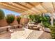 Relaxing backyard patio with pergola, stone benches, and a water feature at 24502 S Starcrest Dr, Sun Lakes, AZ 85248