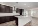 Modern kitchen with island, stainless steel appliances, and dark cabinetry at 25233 N 131St Dr, Peoria, AZ 85383