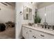 Bathroom featuring double sinks, granite counters, white cabinets, and decorative mirror at 3412 E Indigo Cir, Mesa, AZ 85213