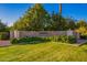 Beautiful community entrance with well manicured landscaping, mature trees, and stone signage at 3412 E Indigo Cir, Mesa, AZ 85213