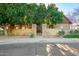 An elegant entrance to a property with stone pillars, mature trees, and beautiful landscaping at 3412 E Indigo Cir, Mesa, AZ 85213