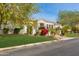 Charming single-story home featuring lush green lawn and manicured desert landscaping at 3412 E Indigo Cir, Mesa, AZ 85213