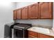 Laundry room with modern appliances and wooden cabinets at 3959 E Gemini Pl, Chandler, AZ 85249