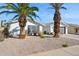 Front view of a white brick house with palm trees and gravel at 4242 E Sacaton St, Phoenix, AZ 85044