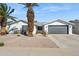 White brick house with gray garage door, landscaping, and palm trees at 4242 E Sacaton St, Phoenix, AZ 85044