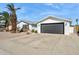 White brick house with gray garage door and mature palm trees at 4242 E Sacaton St, Phoenix, AZ 85044