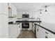 Modern kitchen with white cabinets, black countertops, and stainless steel appliances at 4242 E Sacaton St, Phoenix, AZ 85044