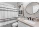 Bathroom with shower and tub combo, white cabinets, framed art, and round mirror at 4311 E Bluefield Ave, Phoenix, AZ 85032