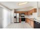 Kitchen with wood cabinets, stainless steel refrigerator, and tile floor at 432 E Harrison St, Chandler, AZ 85225