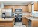 Kitchen features wood cabinets, stainless steel appliances, and an island at 4678 E Jadeite Dr, San Tan Valley, AZ 85143