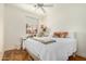 Bright bedroom featuring a ceiling fan, wood floors, and a large window at 46827 N 8Th Ave, New River, AZ 85087