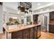 Kitchen island featuring granite countertop and a stainless-steel refrigerator in an open floor plan at 46827 N 8Th Ave, New River, AZ 85087