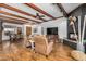 Living room boasts vaulted ceilings with wood beams, hardwood floors, a black fireplace, and neutral furniture at 46827 N 8Th Ave, New River, AZ 85087