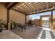 Outdoor patio features a pergola, brick pavers, and iron benches near a stucco wall and gate at 46827 N 8Th Ave, New River, AZ 85087