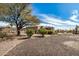 Single-story home with desert landscaping, mature tree, and large gravel area at 46827 N 8Th Ave, New River, AZ 85087