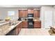 Well-equipped kitchen featuring granite countertops, dark wood cabinets, and a breakfast bar at 4908 S 244Th Ave, Buckeye, AZ 85326