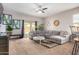 Spacious living room with grey sectional sofa, ceiling fan, and large windows at 4908 S 244Th Ave, Buckeye, AZ 85326